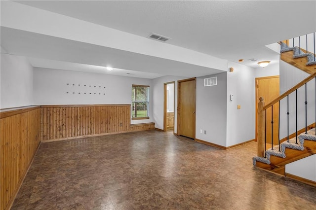 22005 Gracie Dr, Peculiar, MO 64078 - empty room featuring wainscoting, stairway, wooden walls, and tile patterned floors