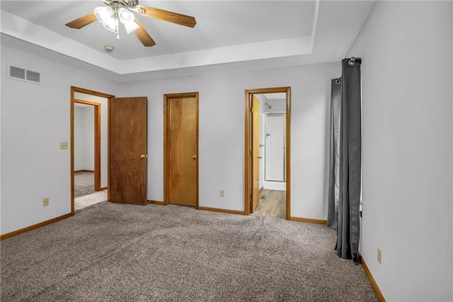 22005 Gracie Dr, Peculiar, MO 64078 - unfurnished bedroom with a tray ceiling, carpet, a ceiling fan, and connected bathroom