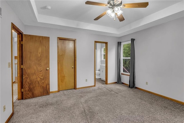 22005 Gracie Dr, Peculiar, MO 64078 - unfurnished bedroom with a tray ceiling, carpet floors, two closets, and ensuite bath