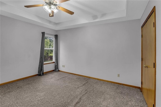 22005 Gracie Dr, Peculiar, MO 64078 - empty room featuring light colored carpet, ceiling fan, and a raised ceiling