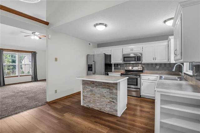 22005 Gracie Dr, Peculiar, MO 64078 - kitchen featuring stainless steel appliances, light countertops, white cabinets, dark wood finished floors, and a center island