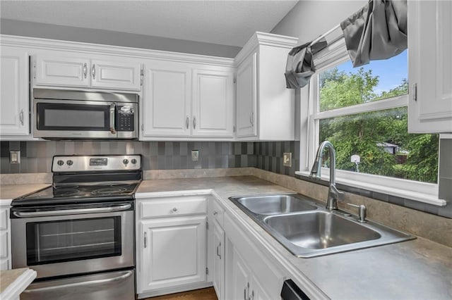 22005 Gracie Dr, Peculiar, MO 64078 - kitchen with appliances with stainless steel finishes, white cabinets, light countertops, and decorative backsplash