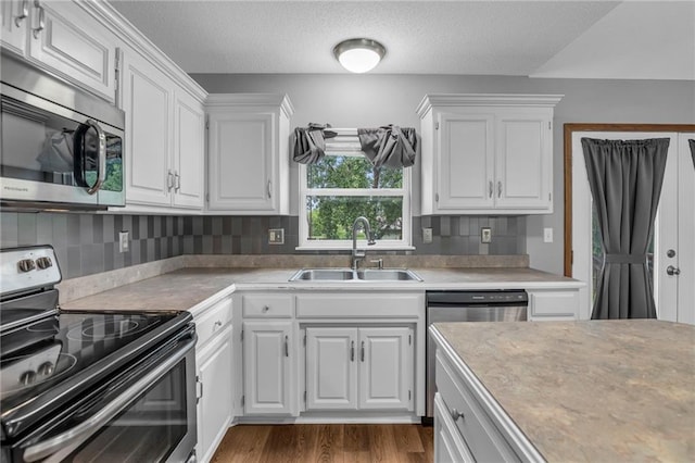 22005 Gracie Dr, Peculiar, MO 64078 - kitchen featuring stainless steel appliances, white cabinets, tasteful backsplash, and a textured ceiling