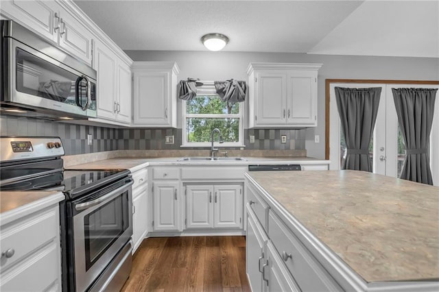 22005 Gracie Dr, Peculiar, MO 64078 - kitchen with appliances with stainless steel finishes, light countertops, white cabinetry, dark wood-style flooring, and a textured ceiling