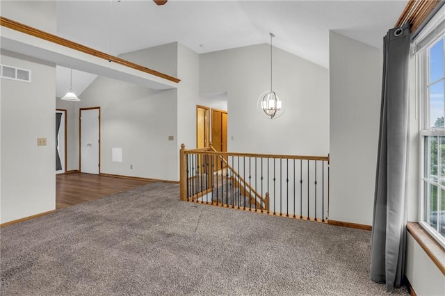 22005 Gracie Dr, Peculiar, MO 64078 - spare room featuring vaulted ceiling, carpet flooring, healthy amount of natural light, a chandelier, and ceiling fan