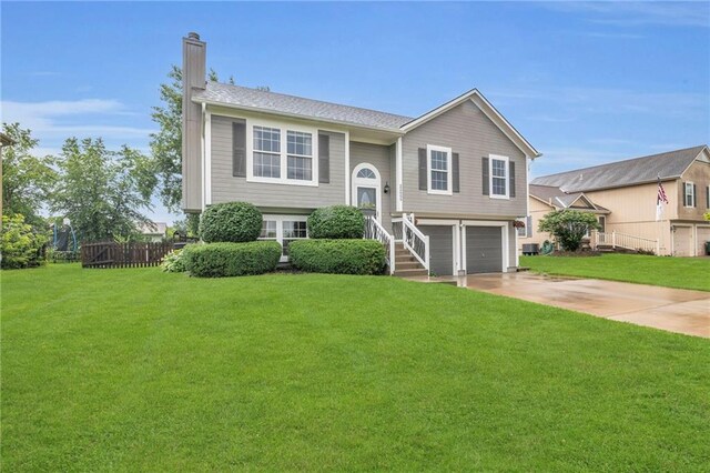 22005 Gracie Dr, Peculiar, MO 64078 - split foyer home featuring an attached garage, a chimney, and driveway