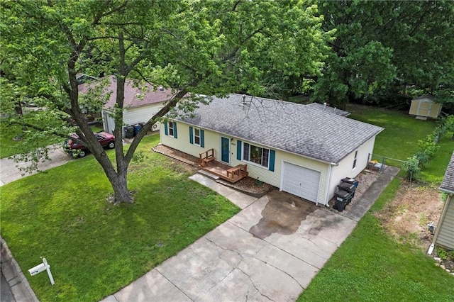 1521 W 22nd St, Lawrence, KS 66046 - view of front facade featuring a storage unit, driveway, a shingled roof, and a garage