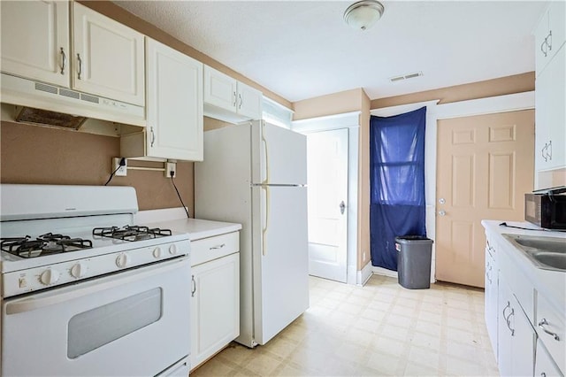 2512 Jules St, Saint Joseph, MO 64501 - kitchen with white appliances, under cabinet range hood, light flooring, and white cabinets