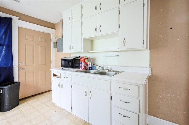 2512 Jules St, Saint Joseph, MO 64501 - kitchen featuring black microwave, light countertops, and white cabinetry