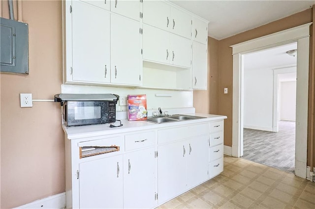 2512 Jules St, Saint Joseph, MO 64501 - kitchen with black microwave, light flooring, electric panel, light countertops, and white cabinets