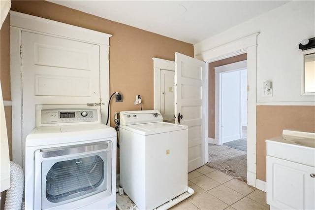 2512 Jules St, Saint Joseph, MO 64501 - laundry room featuring washer and dryer, light tile patterned floors, and cabinet space