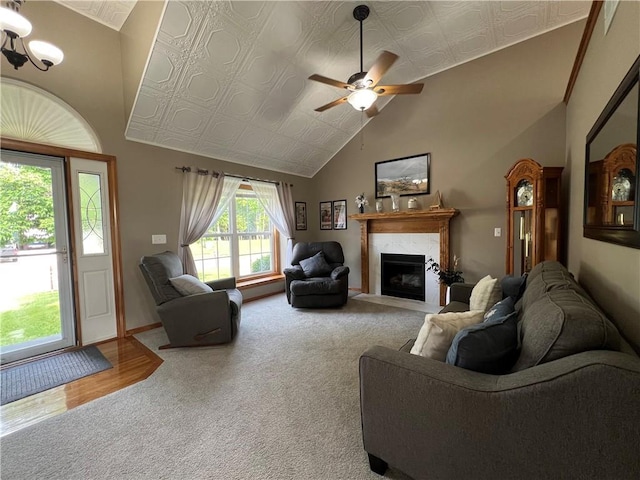 938 S 17th St, Leavenworth, KS 66048 - carpeted living room with a fireplace, ceiling fan, vaulted ceiling, an ornate ceiling, and wood finished floors