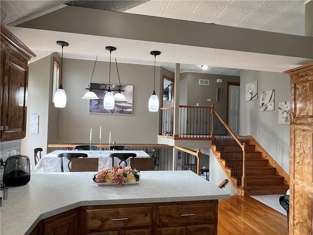 938 S 17th St, Leavenworth, KS 66048 - kitchen featuring light wood-style floors, an ornate ceiling, pendant lighting, light countertops, and a peninsula