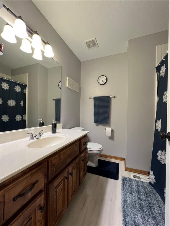 938 S 17th St, Leavenworth, KS 66048 - full bathroom featuring vanity and wood finished floors