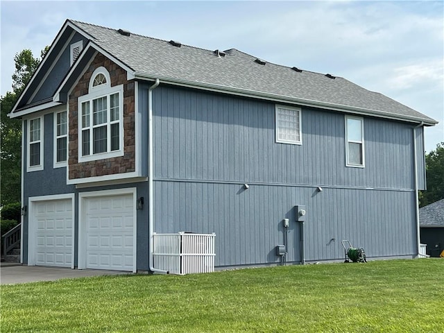 938 S 17th St, Leavenworth, KS 66048 - view of home's exterior with a yard, an attached garage, driveway, stone siding, and roof with shingles