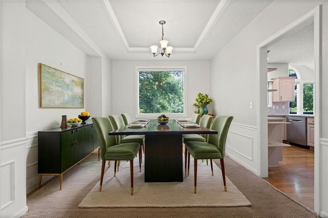18970 W 115th Ter, Olathe, KS 66061 - dining area with healthy amount of natural light, a chandelier, a tray ceiling, and a decorative wall
