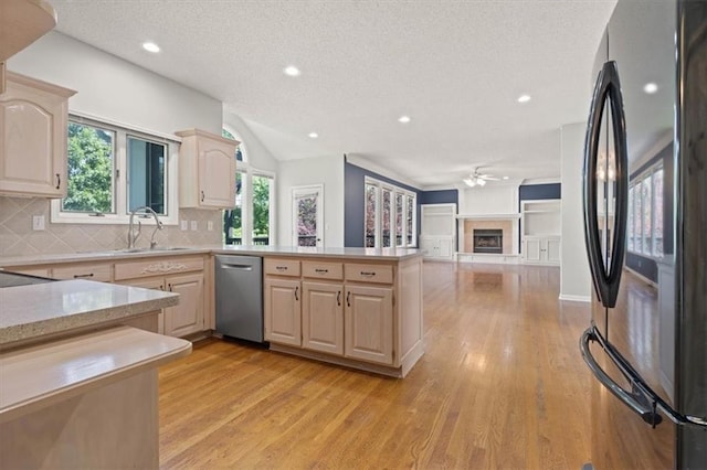 18970 W 115th Ter, Olathe, KS 66061 - kitchen featuring freestanding refrigerator, stainless steel dishwasher, light brown cabinetry, a textured ceiling, and light countertops