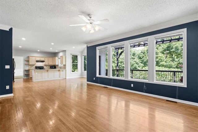 18970 W 115th Ter, Olathe, KS 66061 - unfurnished living room with a textured ceiling, crown molding, light wood-style floors, a ceiling fan, and recessed lighting