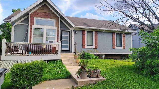 397 W Johnston St, Olathe, KS 66061 - view of front of house featuring stucco siding, a front yard, and a shingled roof
