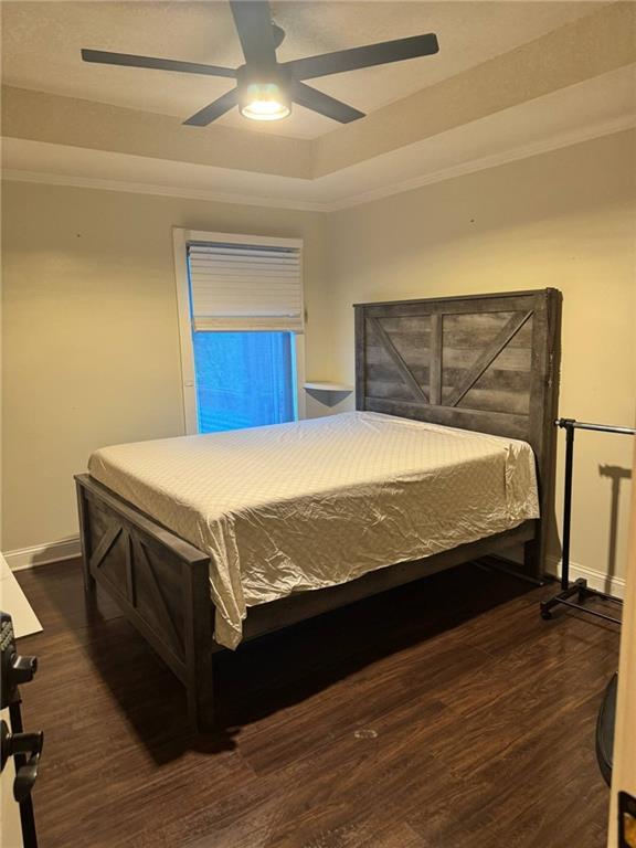 397 W Johnston St, Olathe, KS 66061 - bedroom with dark wood finished floors, ornamental molding, ceiling fan, and a tray ceiling