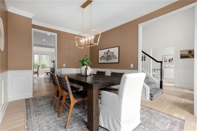 14600 Reinhardt Ln, Leawood, KS 66224 - dining room featuring light wood-type flooring, a chandelier, stairway, crown molding, and a wainscoted wall