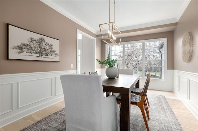 14600 Reinhardt Ln, Leawood, KS 66224 - dining space with ornamental molding, a chandelier, plenty of natural light, a decorative wall, and light wood-style flooring