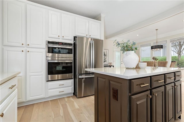 14600 Reinhardt Ln, Leawood, KS 66224 - kitchen with stainless steel appliances, white cabinetry, light wood finished floors, light countertops, and a chandelier