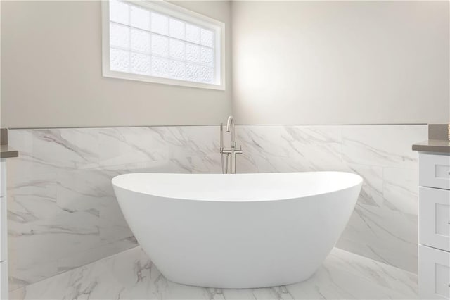 14600 Reinhardt Ln, Leawood, KS 66224 - bathroom featuring tile walls, marble finish floors, a freestanding bath, wainscoting, and vanity
