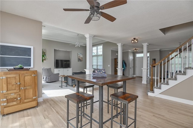 5303 Hallet St, Shawnee, KS 66216 - dining area featuring decorative columns, ceiling fan, and light wood-style flooring