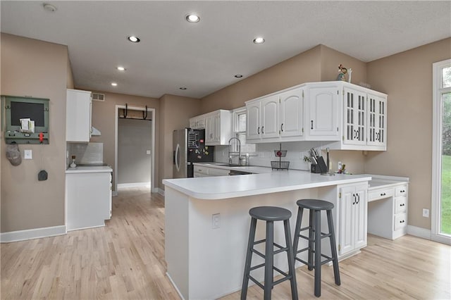 5303 Hallet St, Shawnee, KS 66216 - kitchen with light wood-type flooring, decorative backsplash, freestanding refrigerator, white cabinetry, and recessed lighting