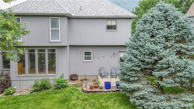 5303 Hallet St, Shawnee, KS 66216 - back of property with a shingled roof, a lawn, and a patio area