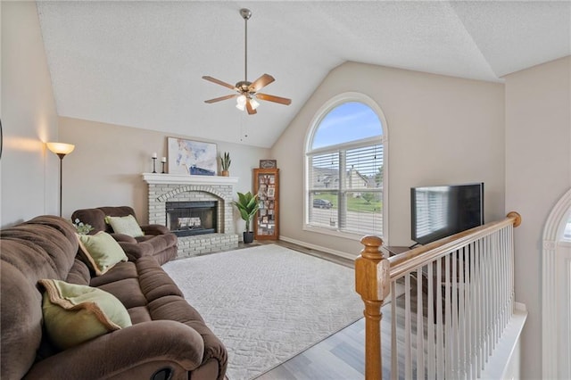 103 Bridgeport Dr, Smithville, MO 64089 - living area featuring vaulted ceiling, wood finished floors, a ceiling fan, a fireplace, and a textured ceiling