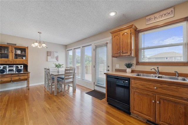 103 Bridgeport Dr, Smithville, MO 64089 - kitchen featuring dishwasher, a textured ceiling, brown cabinetry, light wood-style flooring, and a chandelier