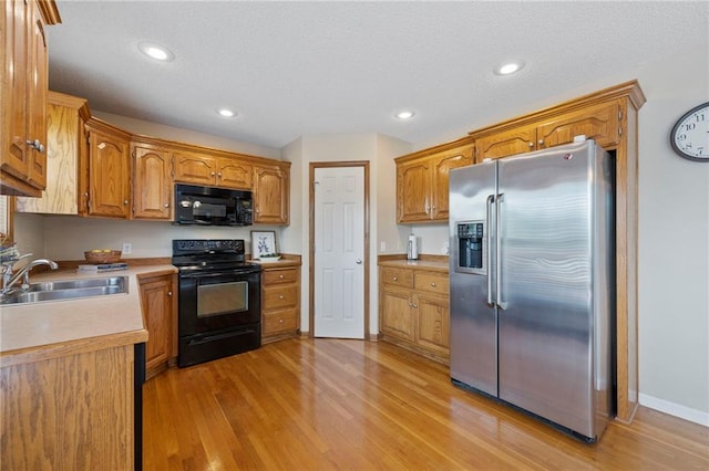 103 Bridgeport Dr, Smithville, MO 64089 - kitchen featuring black appliances, light wood finished floors, brown cabinets, light countertops, and recessed lighting