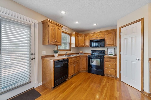 103 Bridgeport Dr, Smithville, MO 64089 - kitchen featuring black appliances, brown cabinets, a textured ceiling, light countertops, and light wood-style floors