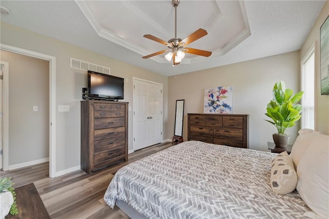 103 Bridgeport Dr, Smithville, MO 64089 - bedroom featuring a raised ceiling, wood finished floors, and a ceiling fan