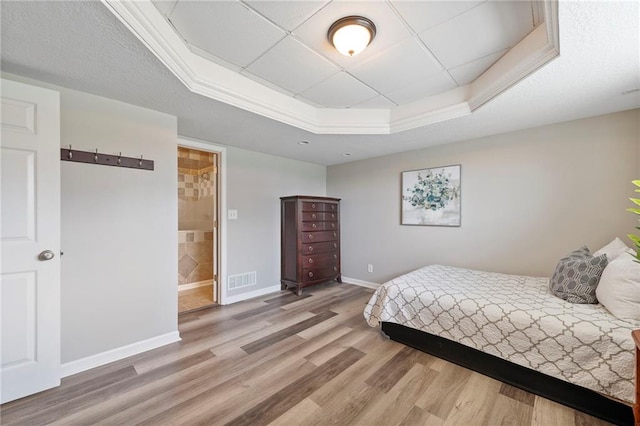 103 Bridgeport Dr, Smithville, MO 64089 - bedroom featuring a tray ceiling, wood finished floors, and connected bathroom