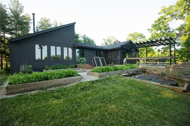 11001 S Perdue Rd, Grain Valley, MO 64029 - back of property featuring a vegetable garden, a lawn, and a pergola