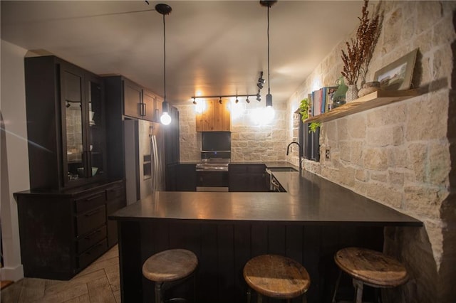 11001 S Perdue Rd, Grain Valley, MO 64029 - kitchen featuring stainless steel fridge, open shelves, a peninsula, glass insert cabinets, and a breakfast bar area