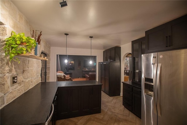 11001 S Perdue Rd, Grain Valley, MO 64029 - kitchen with stainless steel fridge with ice dispenser, dark countertops, a peninsula, arched walkways, and decorative light fixtures