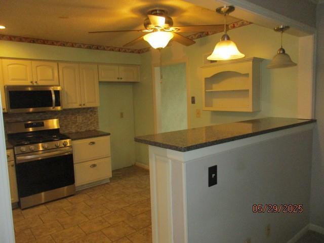 19005 E 18th Ter N, Independence, MO 64058 - kitchen featuring stainless steel appliances, dark countertops, ceiling fan, and pendant lighting