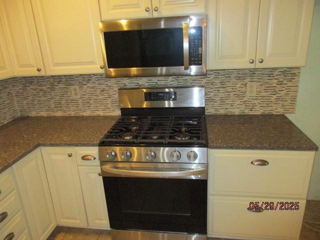 19005 E 18th Ter N, Independence, MO 64058 - kitchen featuring stainless steel appliances, white cabinetry, and backsplash