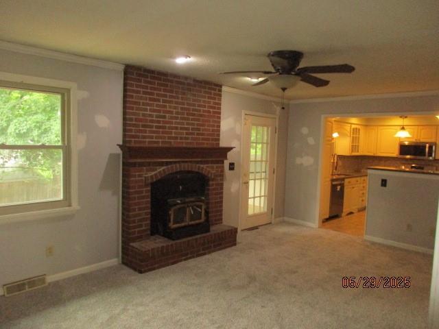 19005 E 18th Ter N, Independence, MO 64058 - unfurnished living room featuring ornamental molding, healthy amount of natural light, a ceiling fan, and light carpet