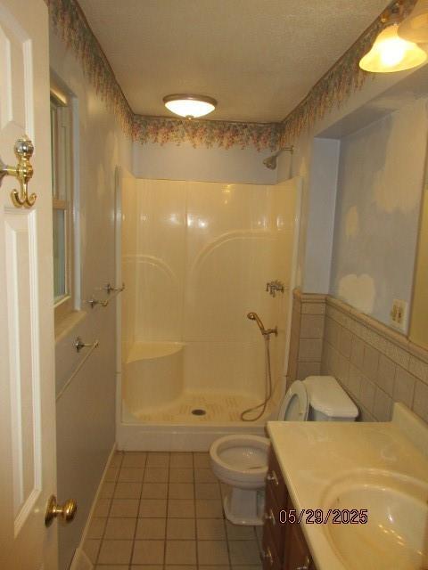 19005 E 18th Ter N, Independence, MO 64058 - full bath featuring tile patterned flooring, a stall shower, toilet, vanity, and a wainscoted wall