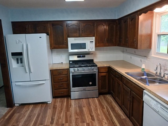 2912 Iva Dr, Independence, MO 64057 - kitchen featuring white appliances, a sink, wood finished floors, and light countertops