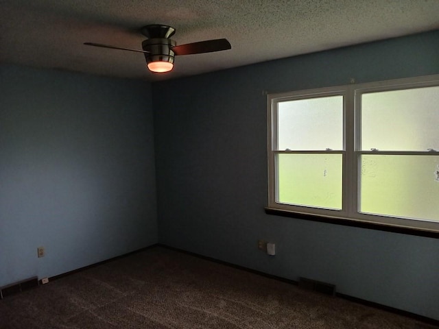 2912 Iva Dr, Independence, MO 64057 - spare room with dark carpet, ceiling fan, and a textured ceiling