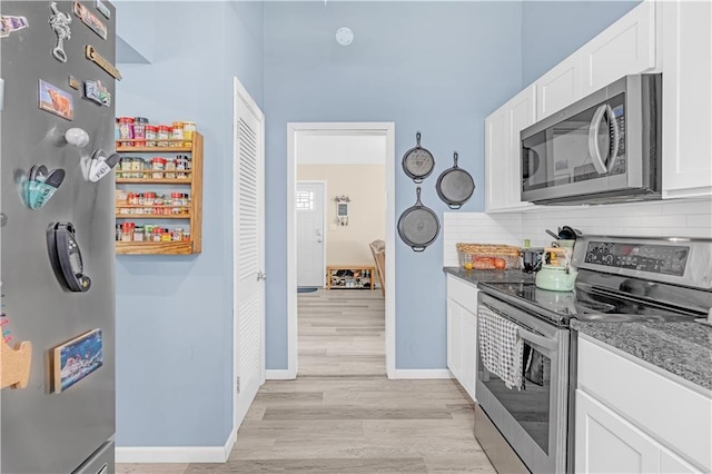 1112 Anderson St, Warrensburg, MO 64093 - kitchen with appliances with stainless steel finishes, light wood-type flooring, white cabinets, and backsplash