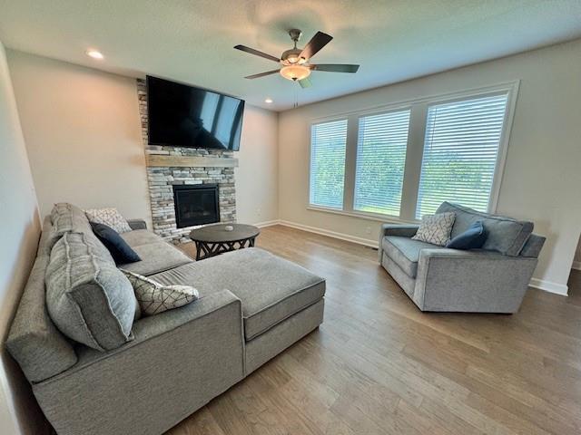 24840 W 178th Ct, Gardner, KS 66030 - living room with a ceiling fan, wood finished floors, a fireplace, and recessed lighting