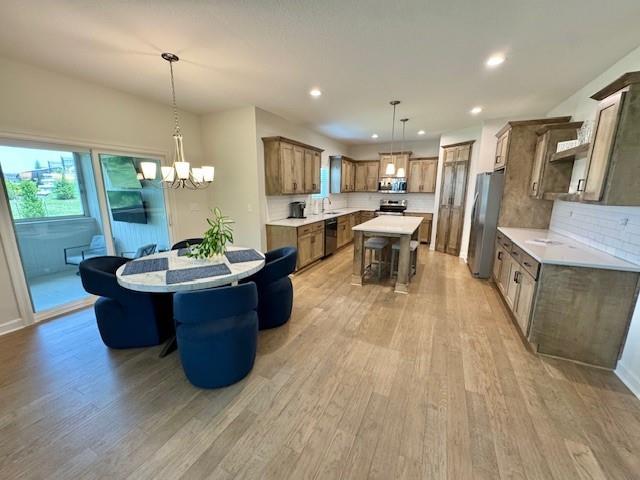 24840 W 178th Ct, Gardner, KS 66030 - dining space with light wood-style flooring, a chandelier, and recessed lighting
