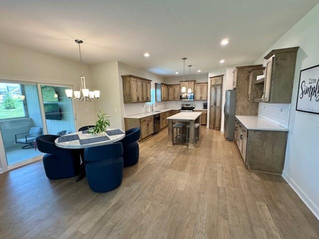 24840 W 178th Ct, Gardner, KS 66030 - kitchen with stainless steel appliances, light wood finished floors, a kitchen island, light countertops, and recessed lighting